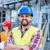 Three engineers with hard hats at a construction site